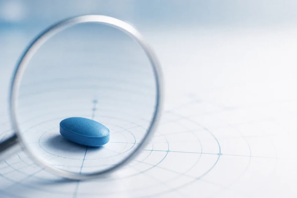 Abstract conceptual image of a single blue pill on a minimalist surface with subtle analytical grid and magnifying lens eleme